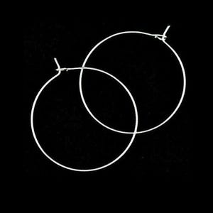 May include: A pair of silver hoop earrings. The earrings are simple and elegant, and they would be a great addition to any jewellery collection.