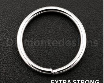 Op de afbeelding: Een cirkelvormige zilverkleurige metalen ring met een gladde, gepolijste afwerking. De ring heeft een enkele zichtbare naad waar de uiteinden samenkomen. De tekst "EXTRA STRONG" staat in witte hoofdletters in de rechterbenedenhoek.