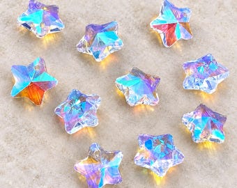 May include: Ten star-shaped beads made of clear, faceted glass with an iridescent finish. Each bead displays a spectrum of colors including blue, purple, and orange reflections. Each star features a small hole near the top point for threading.