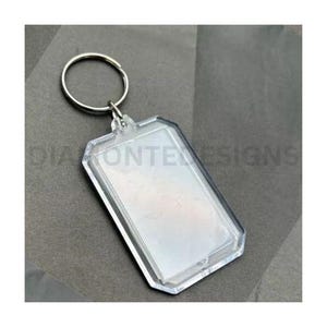 May include: A clear plastic keyring with a rectangular photo insert. The keyring has a silver metal ring.