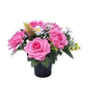 May include: A colourful arrangement of pink roses, white daisies, and greenery in a black pot. The artificial flowers create a bright display, suitable for home decor or as a gift. The arrangement is set against a white background.
