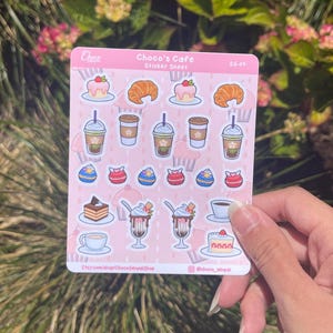 Może przedstawiać: Różowa arkusz naklejek z ilustracjami przysmaków kawiarnianych, w tym ciast, rogalików, kawy i koktajli mlecznych. Tekst "Choco's Cafe" znajduje się na górze. Informacje o mediach społecznościowych znajdują się na dole.