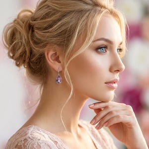May include: Elegant teardrop earrings with a silver-tone setting and a large, faceted, pink gemstone. The earrings dangle gracefully, reflecting light. A classic jewelry piece, suitable for special occasions or everyday wear.