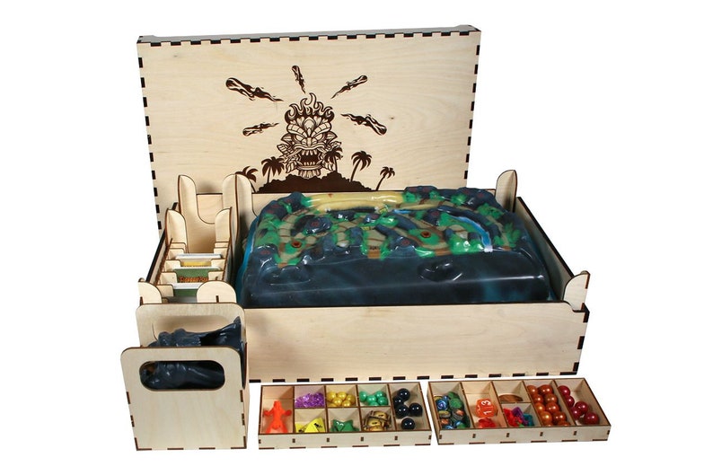 May include: Wooden box with a game board insert, card dividers, and small compartments for game pieces. The box lid features a laser-engraved design of a tiki head with spears.