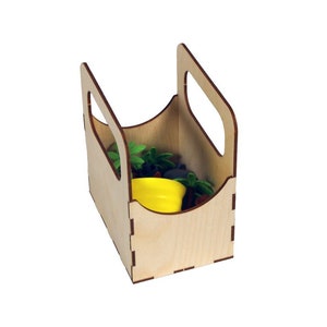 May include: A wooden box with a handle, made of light wood with a brown stain. The box is filled with small potted plants and a yellow watering can.
