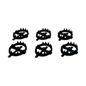 May include: Six black metal trivets with a circular design. Each trivet has a central hub with radiating spokes and a spiked outer edge. The trivets are arranged on a white background.