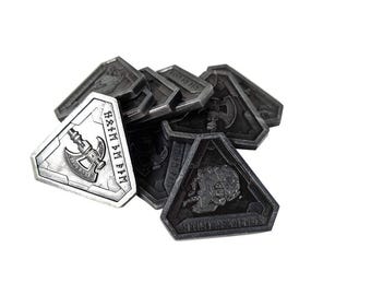 May include: A set of eight silver and black metal tokens with a triangular shape. The silver token features an axe and the text "HÁFIM AM EFIM". The black tokens feature various designs.