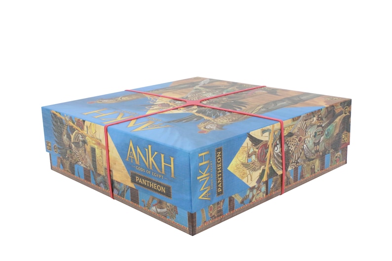 Puede incluir: Una caja azul con las palabras "Ankh Gods of Egypt Pantheon" impresas en ella. La caja est&aacute; envuelta en bandas de goma rojas.