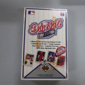 May include: A box of 1991 Upper Deck Baseball cards. The box features a baseball with the text "Baseball 1991 Edition". The box also features a hologram of a baseball player and the text "A Minimum of One 3-D Team Logo Hologram Per Pack! 15 Baseball Cards Per Pack + Random-Sequencing Tamper-Proof Pack Counterfeit-Proof Cards Limited Edition, High-Quality Cards Baseball Heroes Find the Nolan".