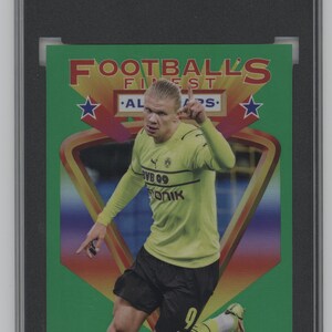 May include: A green and yellow trading card featuring a soccer player in a green and black jersey. The card is titled "Football's Finest" and features the player's name, "Erling Haaland".