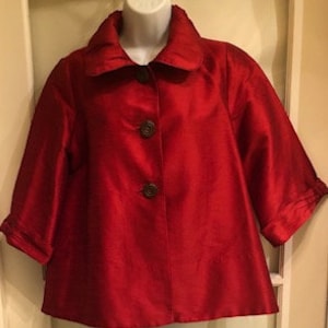 May include: A red, short-sleeved, button-up jacket with a collared neckline.