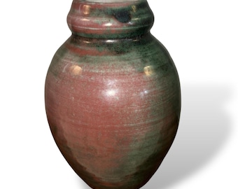 Może przedstawiać: Ręcznie wykonany ceramiczny wazon o zaokrąglonym korpusie i lekko rozszerzającej się szyi. Wazon charakteryzuje się mieszanką ziemistych tonów, z czerwonobrązową podstawą i zielonymi akcentami w pobliżu góry. Powierzchnia ma teksturowany, ręcznie robiony wygląd.