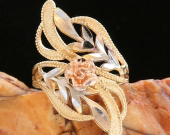 May include: A gold ring with a rose design. The ring is made of three different types of gold: yellow, white, and rose.