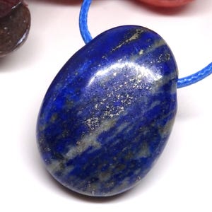Lapis lazuli hole stone pendant with blue macrame ribbon.