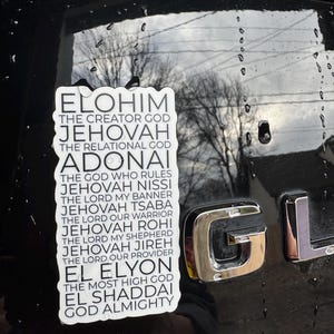 May include: A white sticker with black text on a black car. The text reads "Elohim The Creator God, Jehovah The Relational God, Adonai The God Who Rules, Jehovah Nissi The Lord My Banner, Jehovah Tsaba The Lord Our Warrior, Jehovah Rohi The Lord My Shepherd, Jehovah Jireh The Lord Our Provider, El Elyon The Most High God, El Shaddai God Almighty."