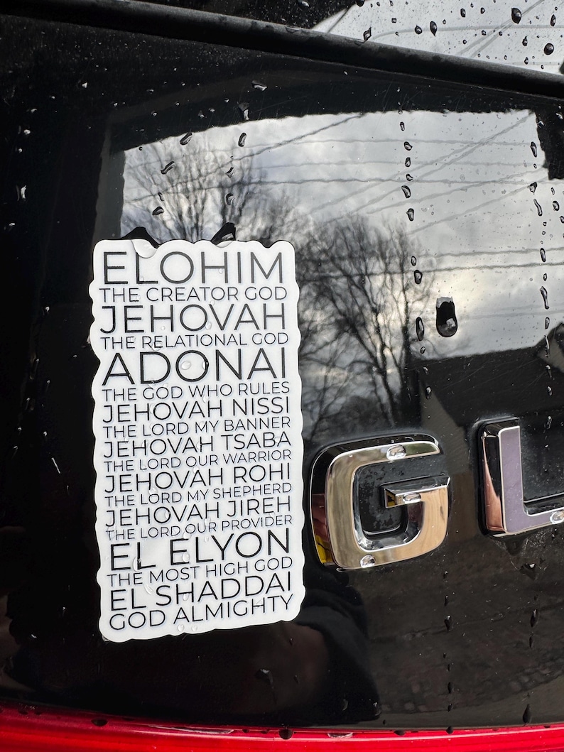 May include: A white sticker with black text on a black car. The text reads "Elohim The Creator God, Jehovah The Relational God, Adonai The God Who Rules, Jehovah Nissi The Lord My Banner, Jehovah Tsaba The Lord Our Warrior, Jehovah Rohi The Lord My Shepherd, Jehovah Jireh The Lord Our Provider, El Elyon The Most High God, El Shaddai God Almighty."