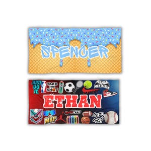 May include: Two personalized sports-themed blankets. The top blanket features a blue ice cream design with the name "Spencer". The bottom blanket has the name "Ethan" with sports-related graphics, including a basketball, baseball, and soccer ball.