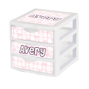 May include: White three-drawer organizer with pink and white gingham pattern and the name Avery on each drawer.