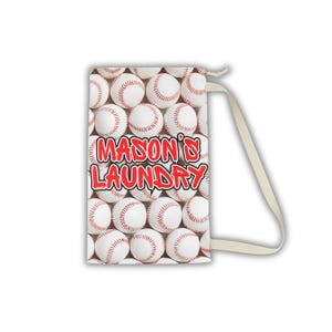 May include: A white laundry bag featuring a pattern of baseballs with red stitching. The bag has the text "MASON'S LAUNDRY" in red. It includes a cream-colored strap for carrying.