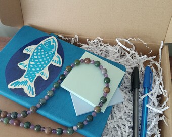 A journaling kit with a blue fish or a lavender dragonfly.