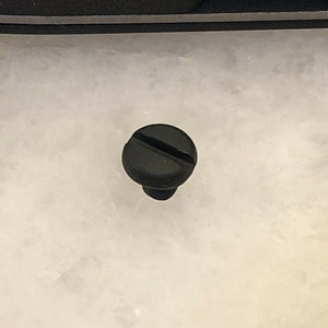 Puede incluir: Un tornillo de pl&aacute;stico negro con una sola ranura en la cabeza.