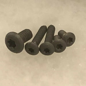 May include: Five black screws with a star-shaped head. The screws are different lengths.