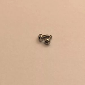 May include: Three silver screws with a hexagonal head.