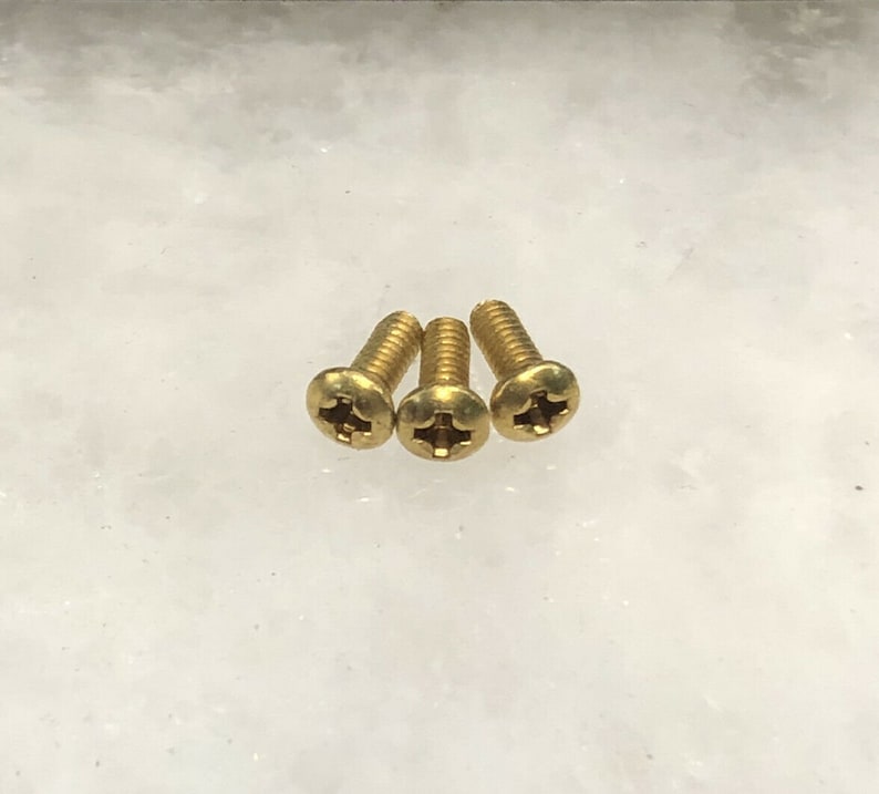 May include: Three gold-coloured screws with a Phillips head.