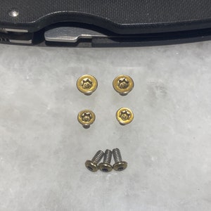 以下が含まれることがあります： 星形の頭部を持つ金色のネジが5本と、平らな頭部を持つ銀色のネジが3本