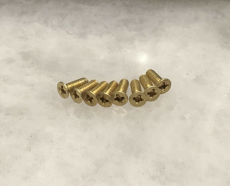 May include: A close-up of ten gold-colored screws with a star-shaped head.