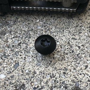 Könnte beinhalten: Eine schwarze Schraube mit einem sternförmigen Kopf.