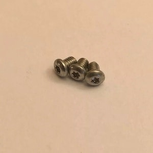 May include: Four silver screws with a star-shaped head.