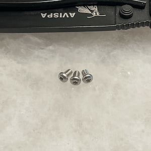 May include: Three silver screws with a star-shaped head.