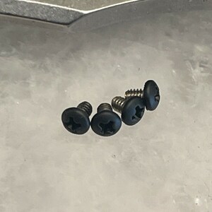 Puede incluir: Cuatro tornillos negros con cabeza de estrella.