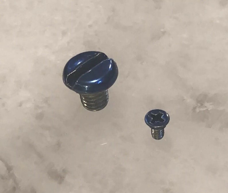 May include: Two blue screws of different sizes. The larger screw has a slotted head, while the smaller screw has a Phillips head. Both screws have silver threads and a shiny blue finish.