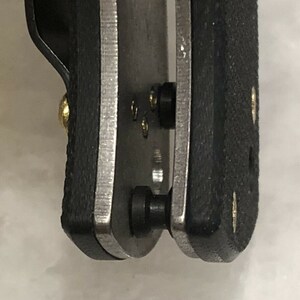 May include: Close-up of a black and silver pocket knife with a black handle and a silver blade. The knife has a pocket clip and a small gold screw.