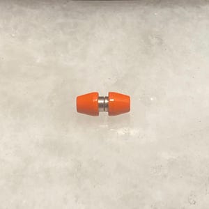May include: A pair of orange earplugs with a silver metal connector in the middle.