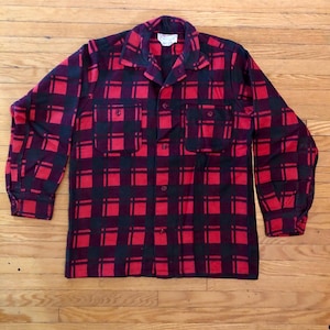 May include: A red and black checked flannel shirt with long sleeves and a button-up front.
