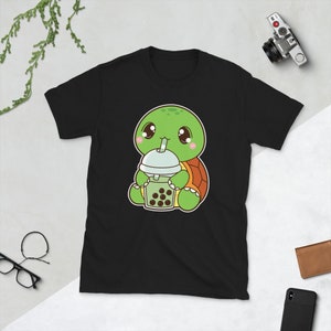 May include: Black t-shirt with a cartoon illustration of a green turtle wearing a brown shell and holding a green boba tea with a straw.