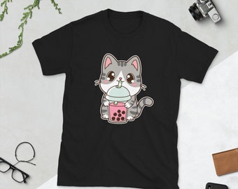 May include: Black t-shirt featuring a cartoon illustration of a grey and white cat drinking pink bubble tea with black boba.