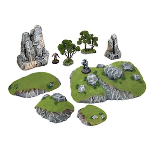 May include: A set of miniature terrain pieces for tabletop gaming, featuring rocky outcroppings, grassy hills, and small trees. The pieces are painted in realistic shades of gray, green, and brown.