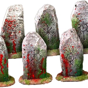 May include: Six grey stone standing stones with red and green paint and various symbols carved into them.