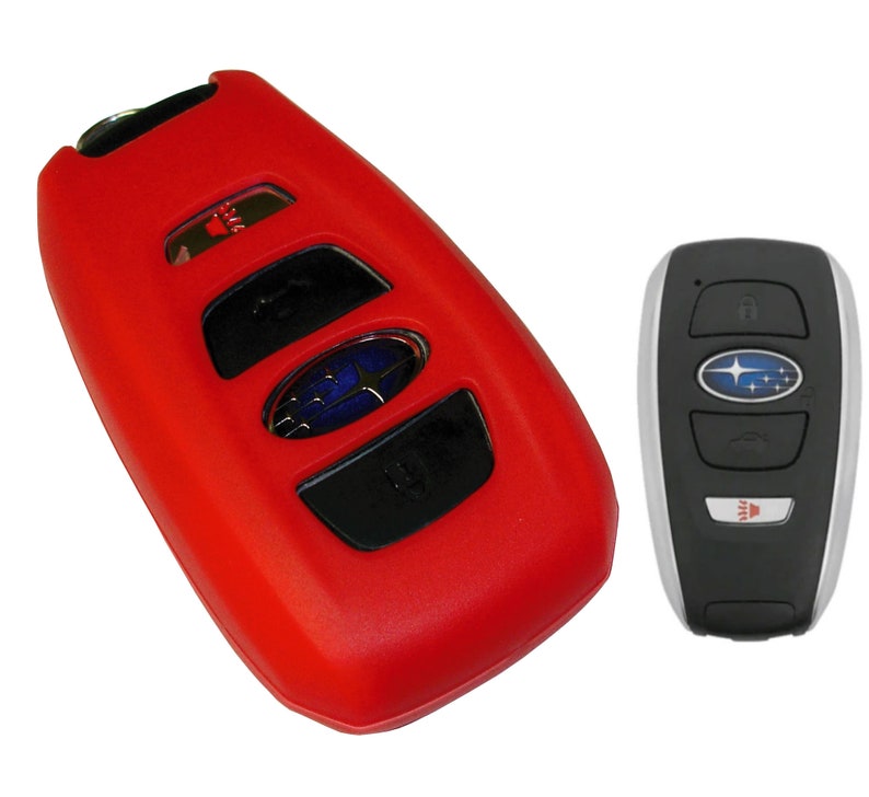 May include: Red silicone key fob cover for a Subaru car key. The key fob has four buttons and a Subaru logo. The key fob is next to a silver and black Subaru car key.