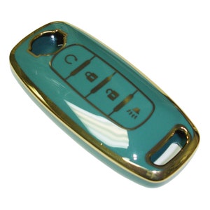 May include: Teal car key fob with gold trim and buttons. The buttons have symbols for lock, unlock, and trunk release.