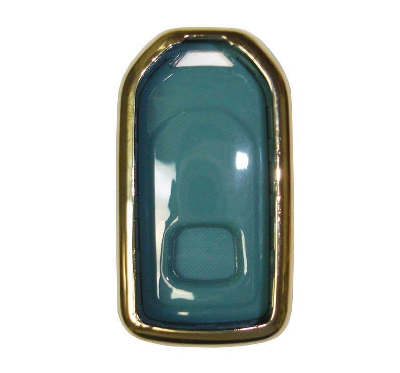 May include: A teal blue key fob case with a gold metal frame. The case has a clear plastic cover and a small button on the front.