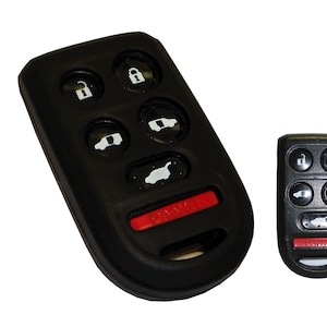 May include: Two black car key fobs with six buttons each. The key fobs have a red button on the side. The key fobs have a white car icon and a lock icon on the buttons.