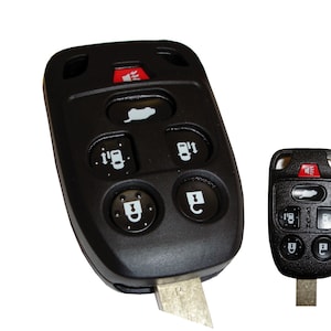 May include: Black car key fob with six buttons, including lock, unlock, trunk release, and panic. The key fob has a red LED light and a silver key blade.