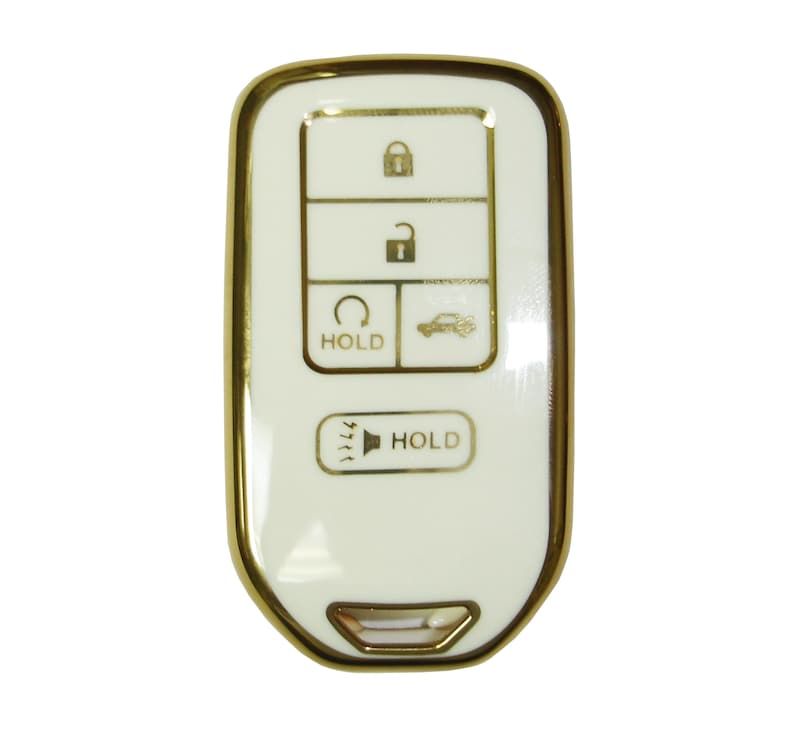 May include: A white car key fob with a gold trim. The key fob has five buttons: lock, unlock, trunk release, panic, and a button with a car icon and the word "HOLD".