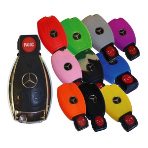 May include: A collection of colorful silicone key covers for a Mercedes-Benz car key. The covers are in various colors, including red, green, pink, blue, yellow, orange, black, and gray. The key covers are designed to protect the car key from scratches and wear and tear.
