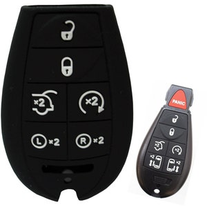 May include: A black car key fob with a panic button and multiple buttons, including lock, unlock, trunk release, and panic. The key fob has a black rubber cover.